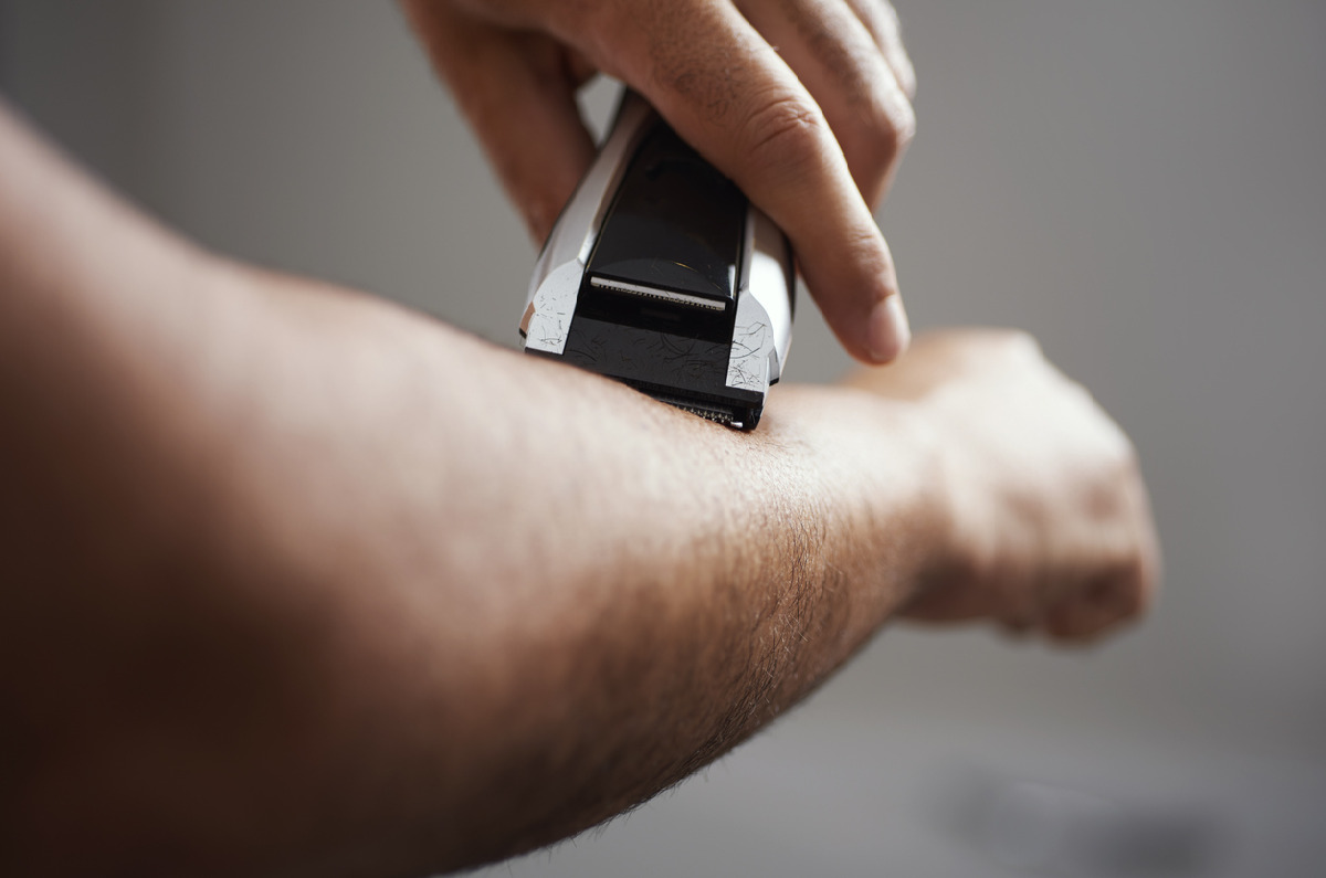 腕のムダ毛処理をする男性の画像