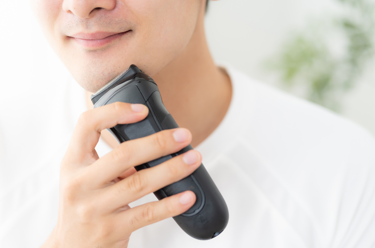 シェーバーで髭を剃る男性