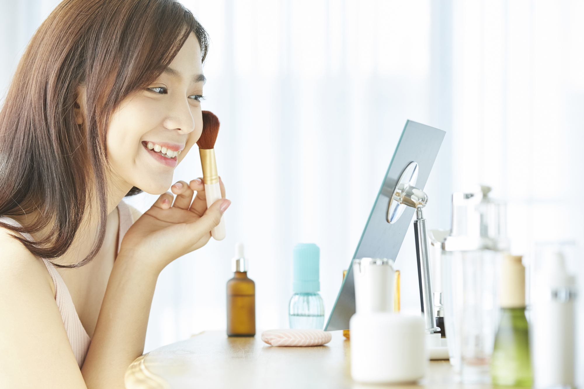 女性がメイクをしているイメージ画像