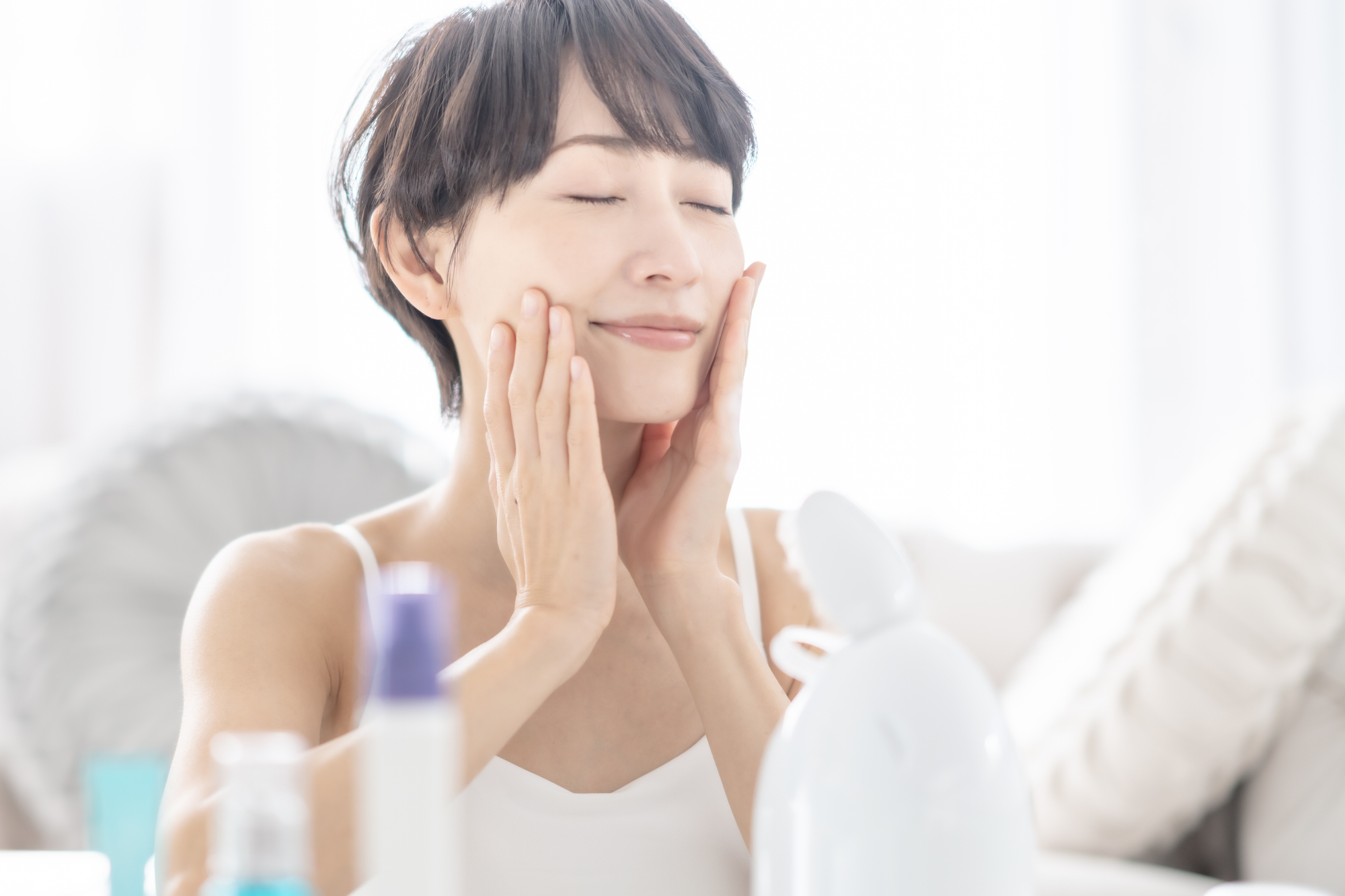 フェイススチーマーの蒸気を顔に当てている女性のイメージ画像