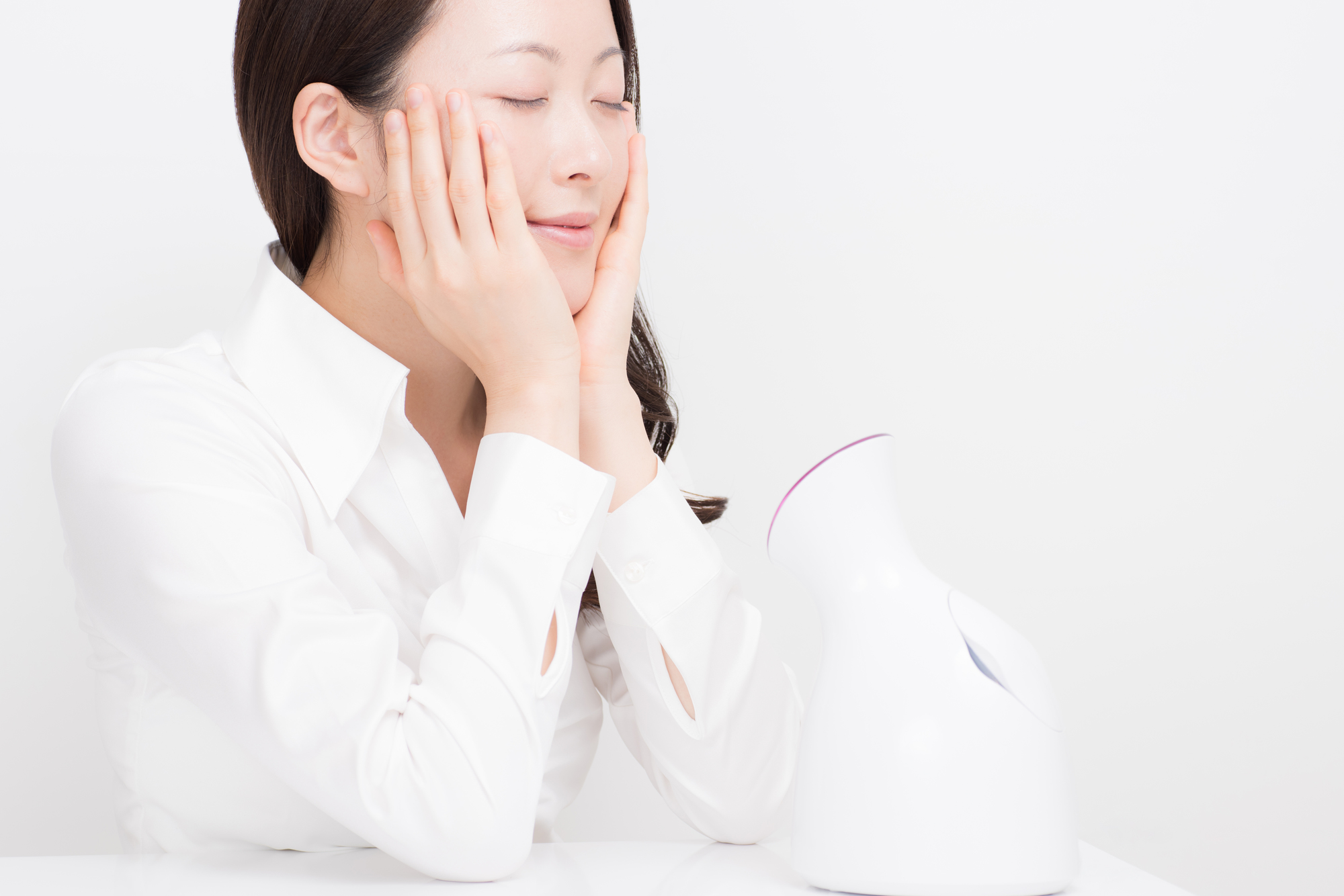 フェイススチーマーを使用する女性