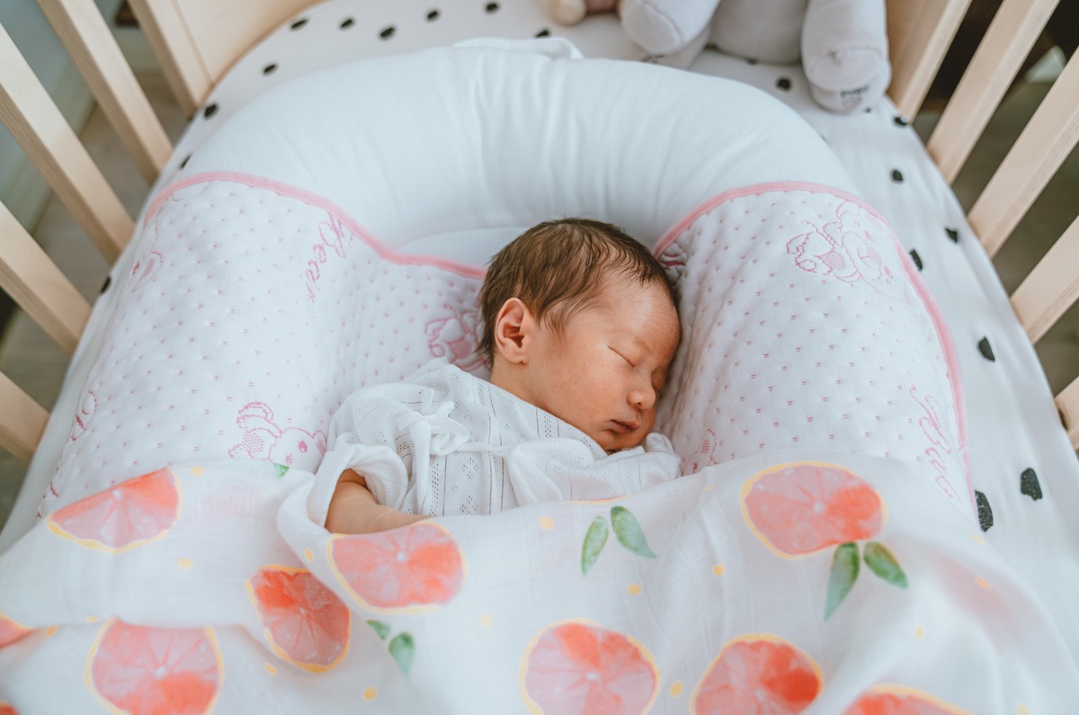 ベビーベッドで寝ている赤ちゃんのイメージ画像