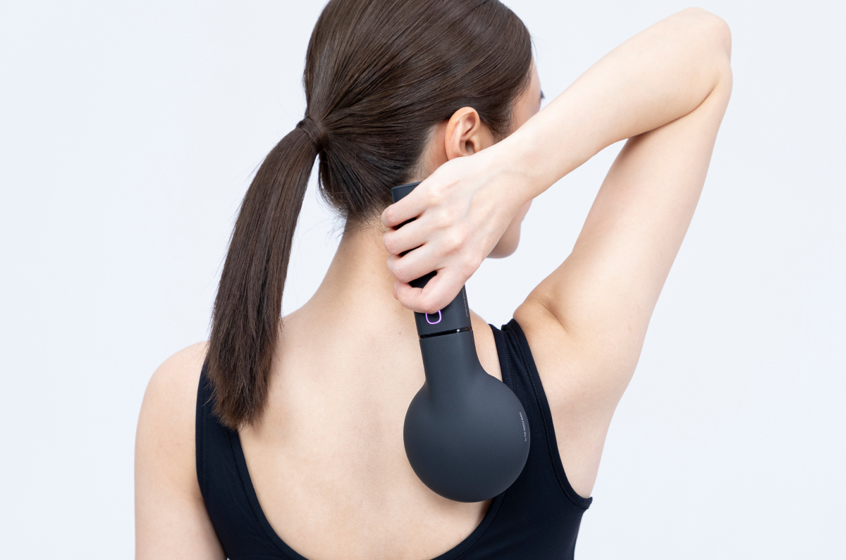 電気バリブラシで顔をマッサージする女性