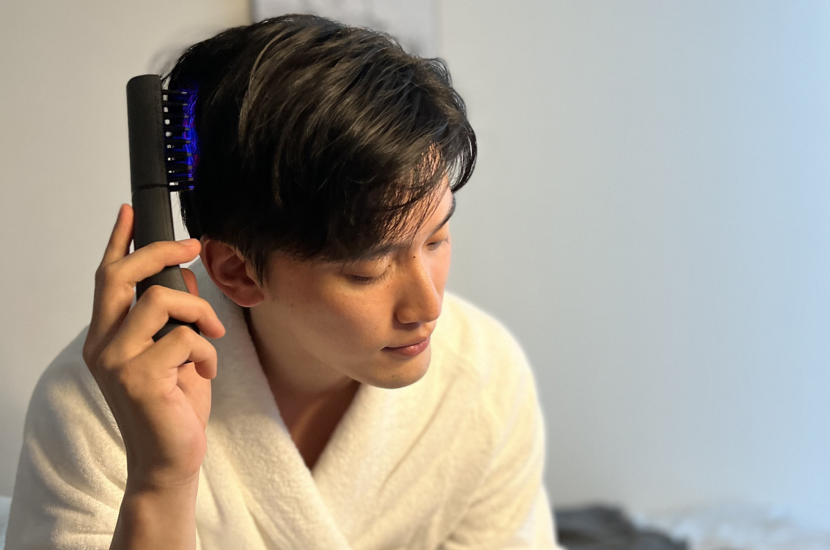 浴室で電気バリブラシを使用している男性