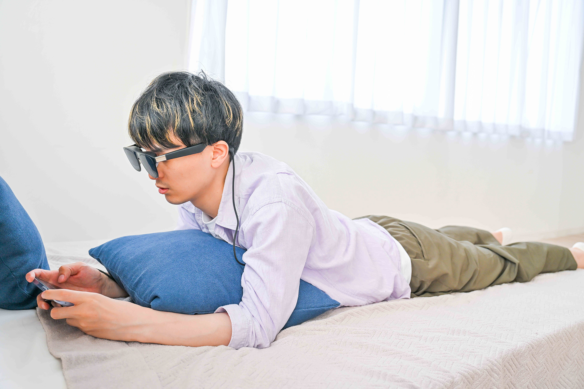 リラックスした格好でスマートグラスをかけている男性