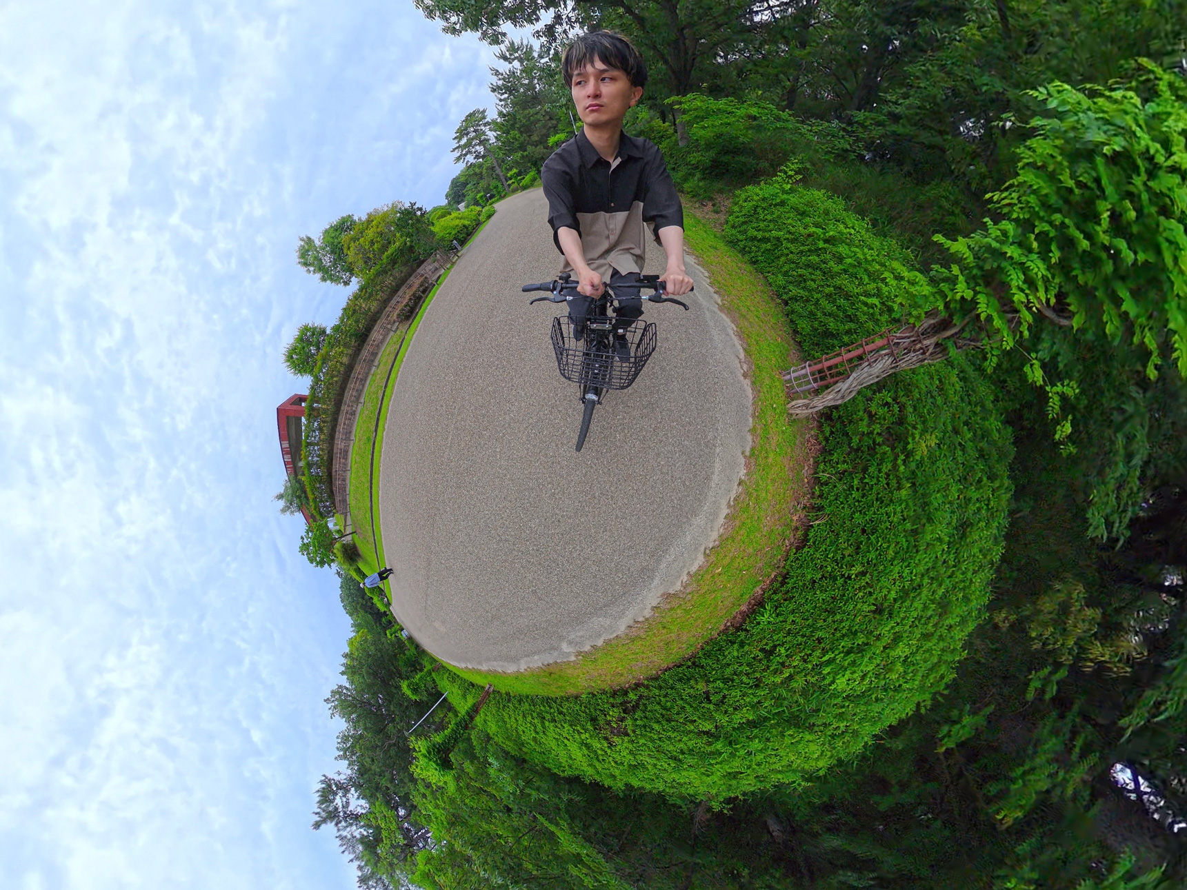 自転車に乗りながら360度カメラを撮影している